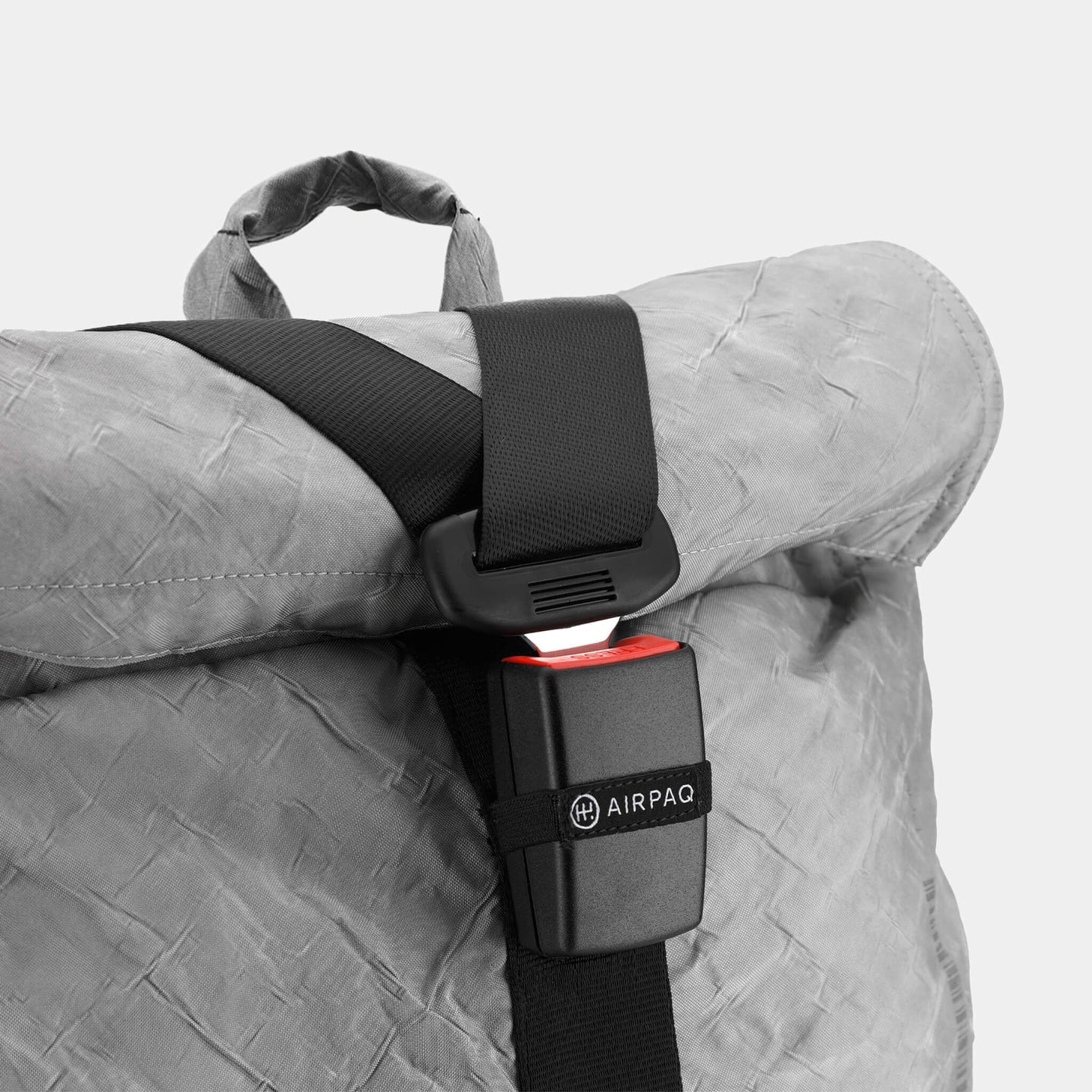 Grauer Rucksack mit schwarzem Sicherheitsgurt und Schnalle, die mit "Airpaq" beschriftet ist.