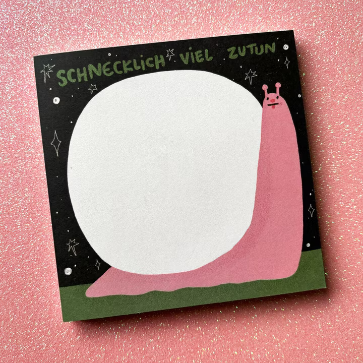 Eine rosa Schnecke auf einem Notizblock mit dem Text "SCHNECKLICH VIEL ZUTUN" auf einem glitzernden rosa Hintergrund.