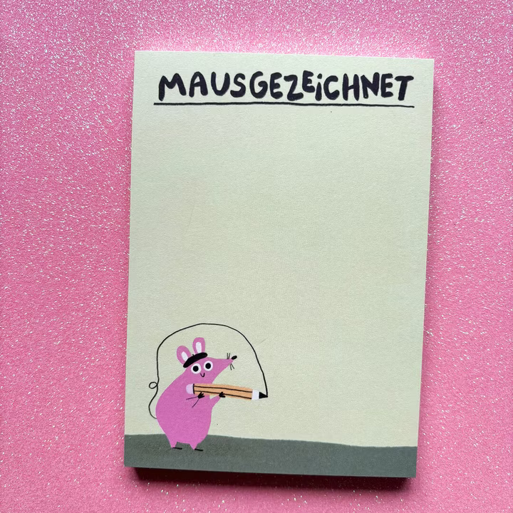 Notizblock auf pinkem Hintergrund, "MAUSGEZEICHNET" oben, mit kleiner rosa Maus, die einen Bleistift hält, unten links.