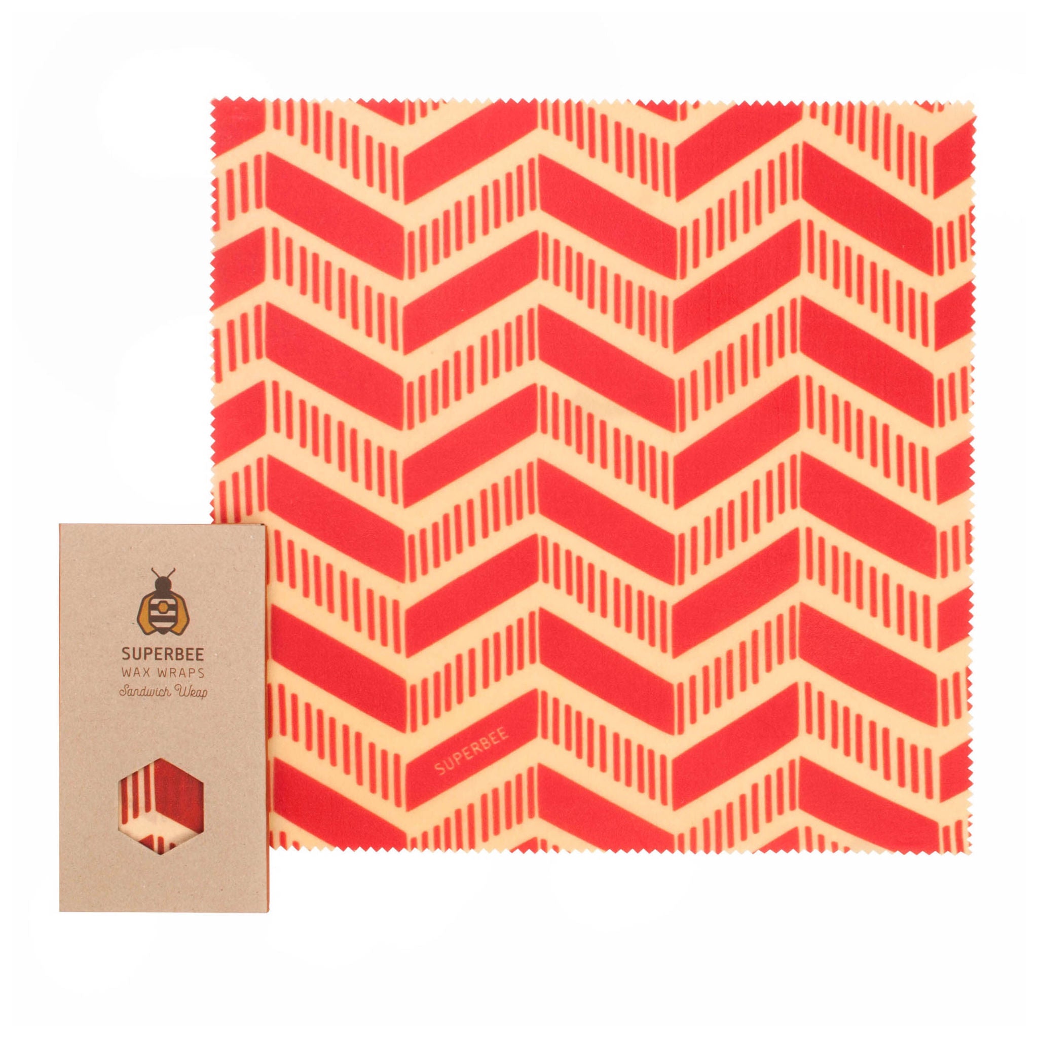 Eine wiederverwendbare Bienenwachsfolie mit rotem und cremefarbenem Zickzackmuster wird neben der braunen Kartonverpackung mit der Aufschrift Superbee Wax Wraps ausgestellt.