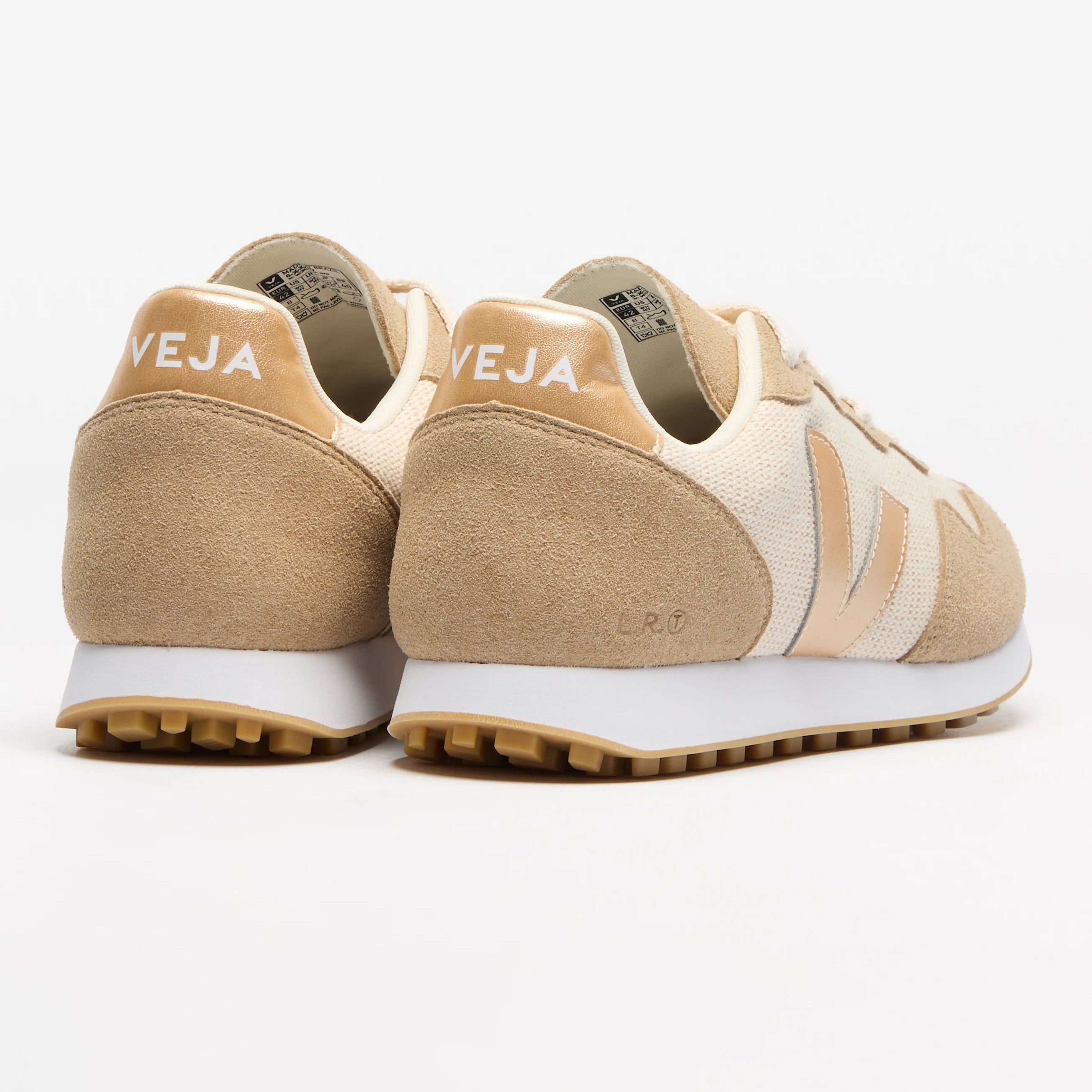 Ein Paar beige-weiße Veja-Sneakers mit Wildleder- und Mesh-Einsätzen, mit dem Markenlogo an der Ferse und dem V an der Seite, das auf weißem Hintergrund dargestellt ist.