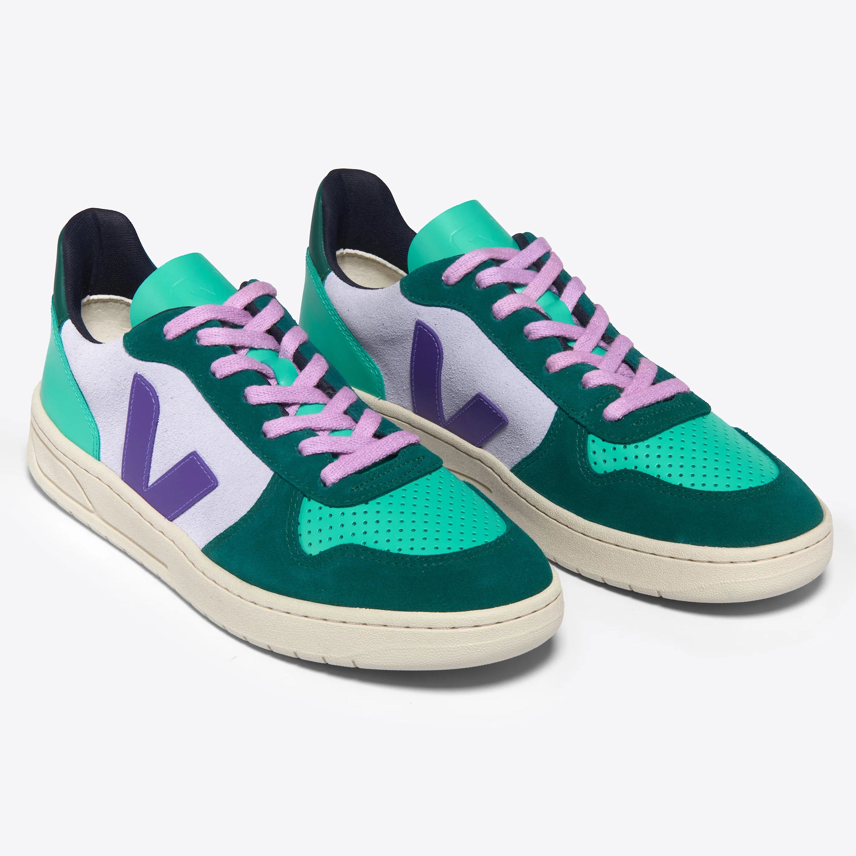 Ein Paar modische Turnschuhe mit blaugrünen und weißen Einsätzen, grünen Zehenkappen, violetten V-Logos an den Seiten, hellvioletten Schnürsenkeln und cremefarbenen Sohlen, die vor einem einfarbigen Hintergrund gezeigt werden.