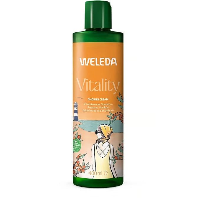Eine 400-ml-Flasche Weleda Vitality Shower Cream mit grüner Kappe, auf deren Etikett eine Person in einem gelben Handtuch abgebildet ist, die auf das Meer, Sanddornzweige und einen entfernten Leuchtturm blickt.