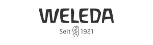 Logo von Weleda mit dem Text "Seit 1921" und einem stilisierten Symbol in der Mitte darunter.
