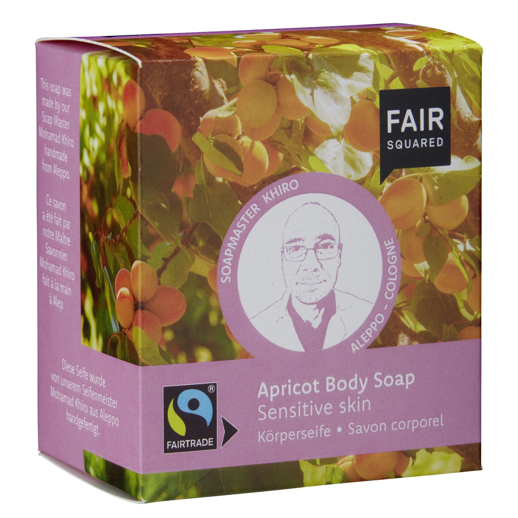 Eine Schachtel FAIR SQUARED Aprikosen-Körperseife für empfindliche Haut mit Abbildungen von Aprikosen, einem Porträt von Soapmaster Khiro und dem Fairtrade-Logo auf der Vorderseite. Der Text wird in mehreren Sprachen angezeigt.