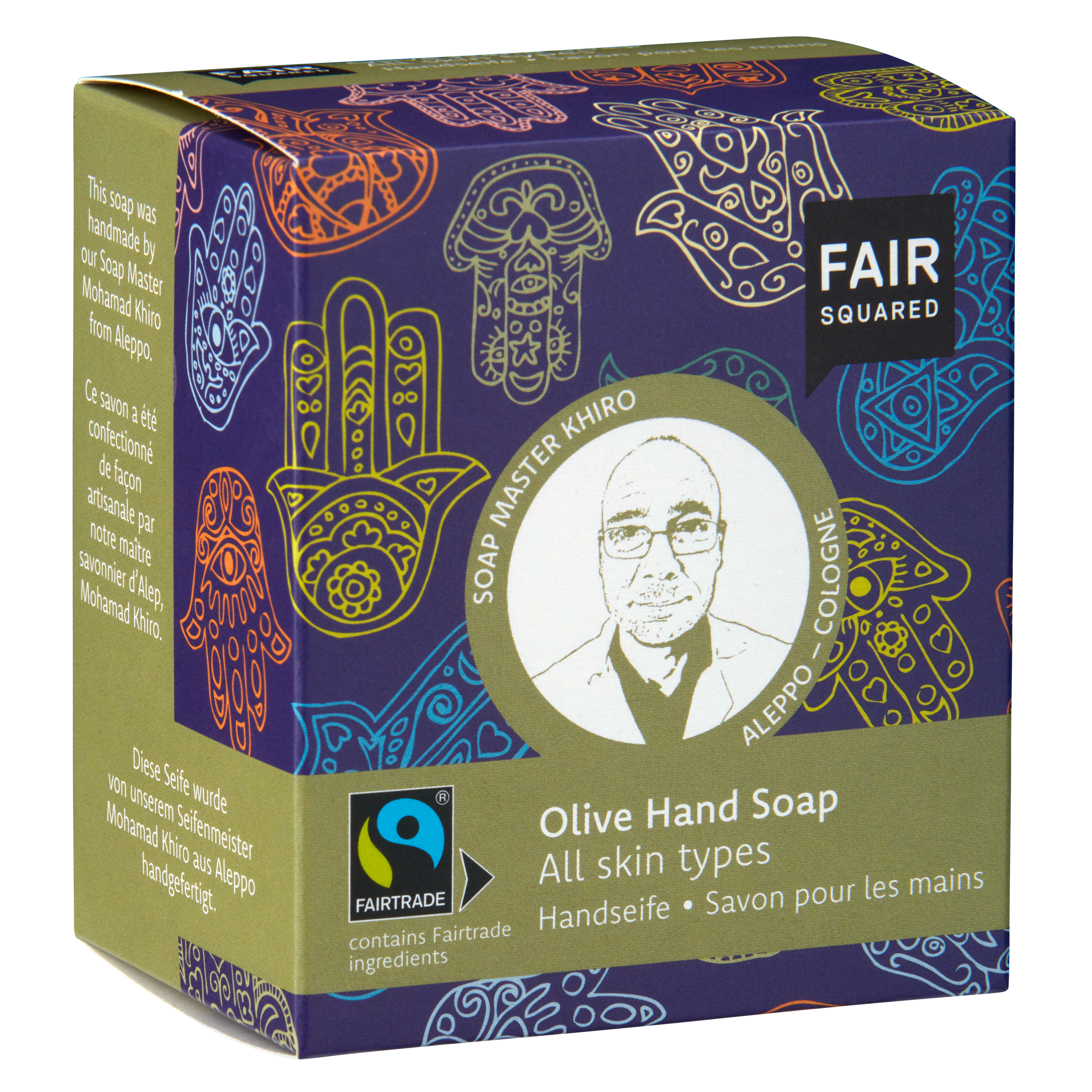 Eine Schachtel Fair Squared Olive Hand Soap mit bunten Hand- und Blattmustern, einer Skizze eines Mannes mit der Aufschrift Soap Master Khiro und dem Hinweis, dass sie für alle Hauttypen geeignet ist und Fairtrade-Zutaten enthält.
