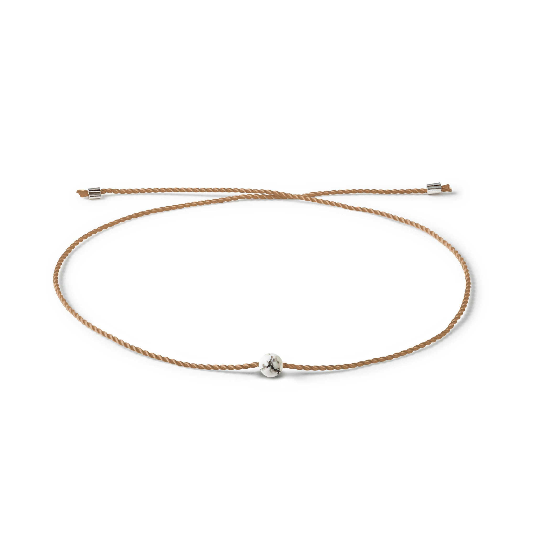 Braunes geflochtenes Armband mit einer kleinen weißen Marmorperle in der Mitte.