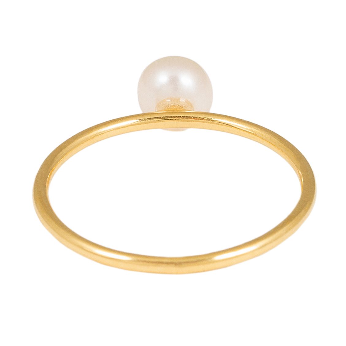 Ein dünner Goldring mit einer einzelnen runden weißen Perle an der Spitze, die auf einem schlichten weißen Hintergrund steht.