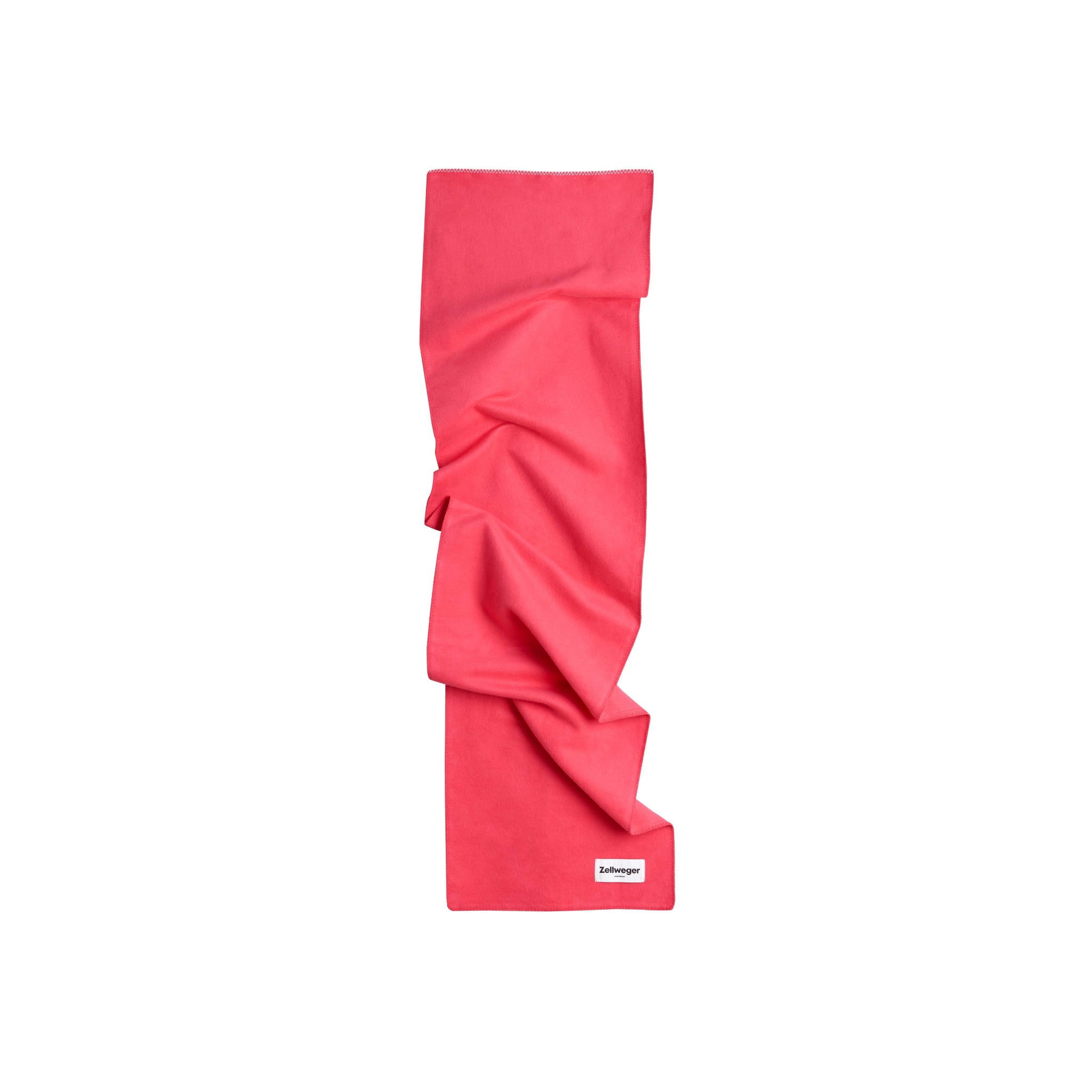Rotes, gefaltetes Handtuch mit einem kleinen Label in der Ecke auf weißem Hintergrund.
