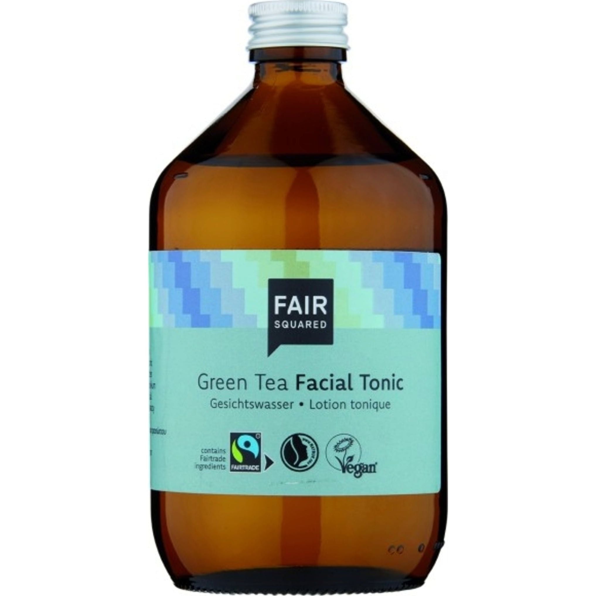 Eine braune Glasflasche mit einem blau-grünen Etikett mit der Aufschrift Fair Squared Green Tea Facial Tonic. Auf dem Etikett befinden sich Symbole für Fairtrade, Vegan und Grausamkeitsfreiheit. Der Flaschendeckel ist silbern.
