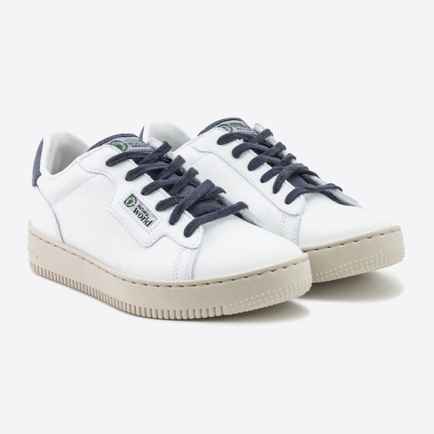 Weiße Sneaker mit dunkelblauen Schnürsenkeln und beigefarbener Sohle auf weißem Hintergrund.