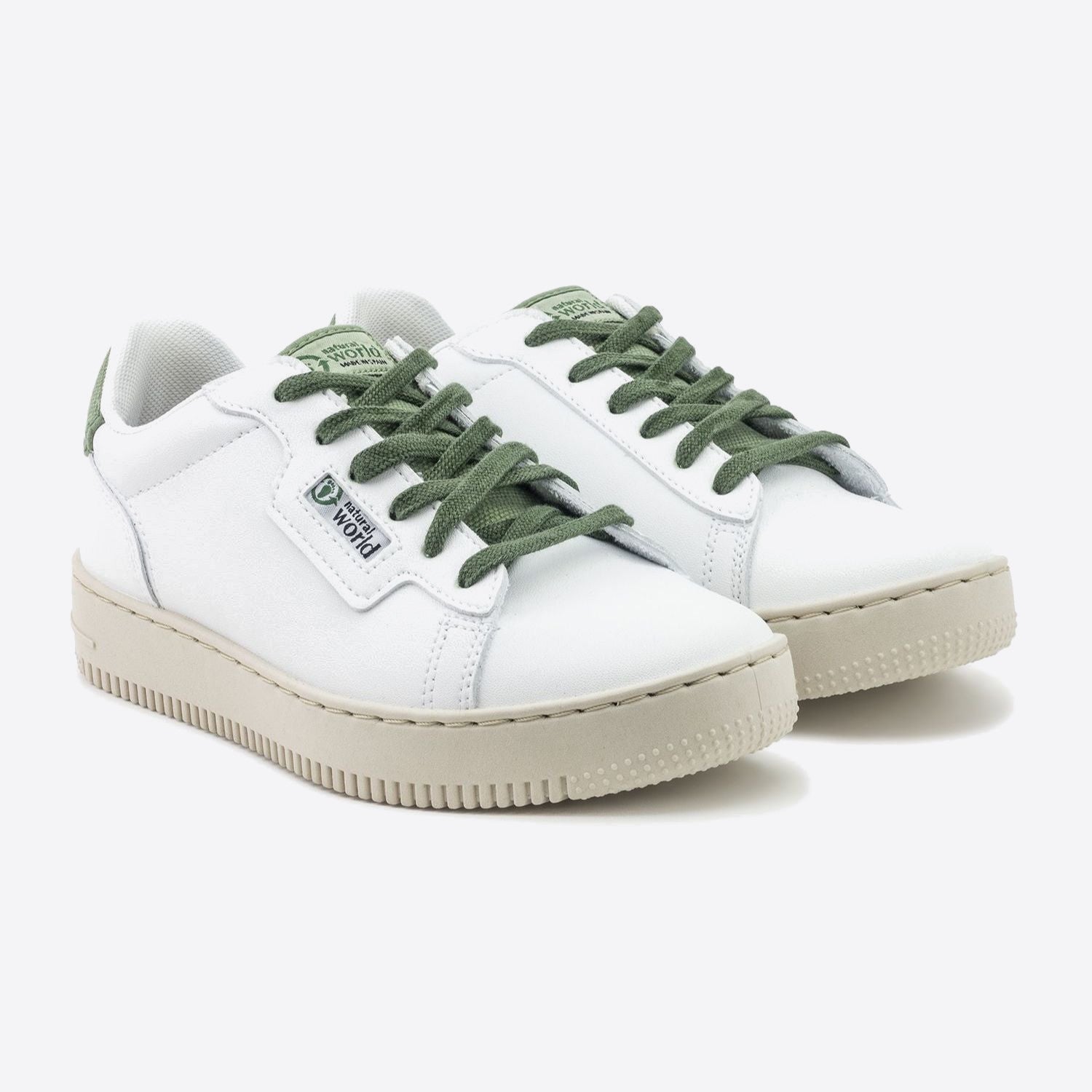 Weiße Sneaker mit grünen Schnürsenkeln und beige Sohlen auf weißem Hintergrund.