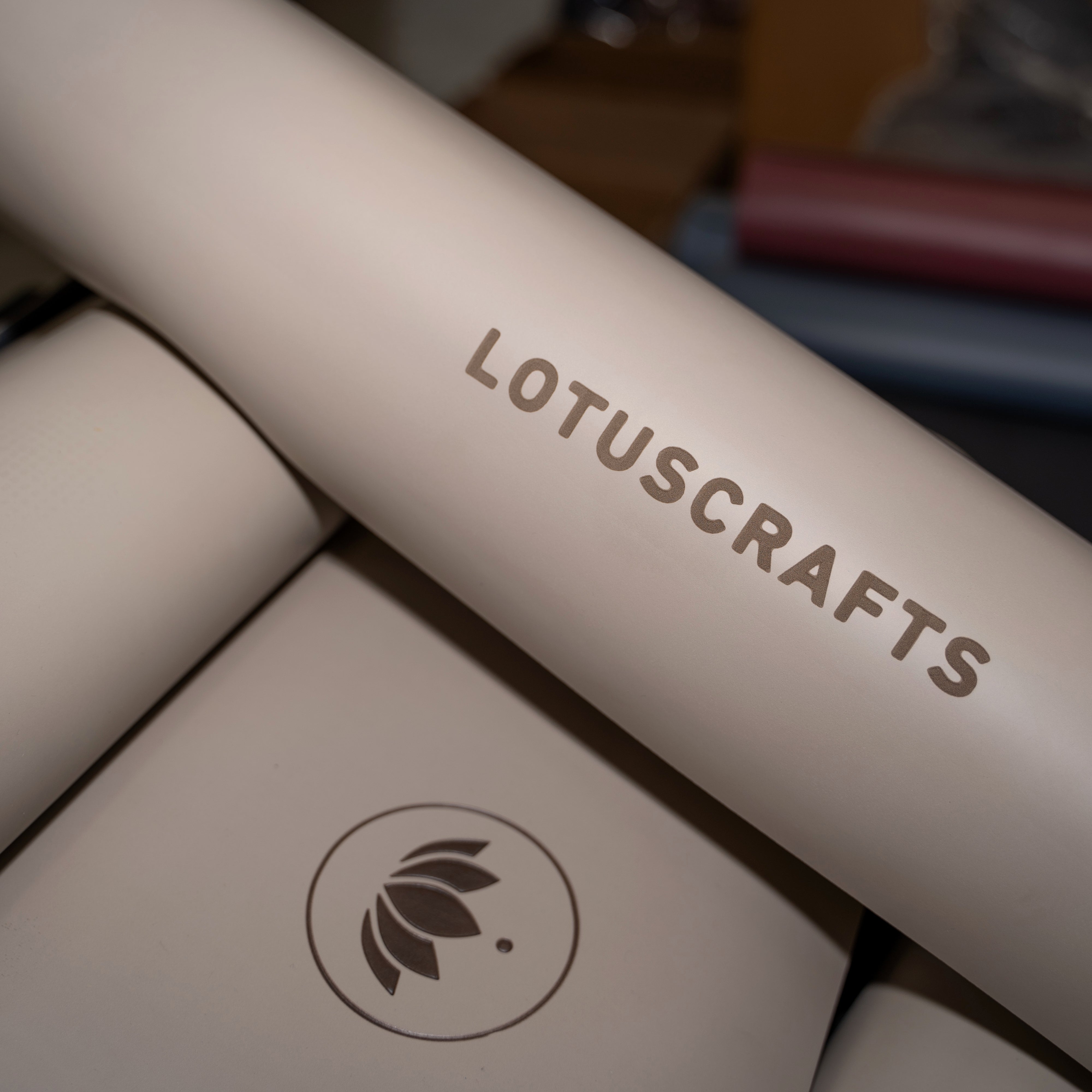 Nahaufnahme von Yogamatten mit dem Aufdruck "LOTUSCRAFTS" und einem Lotus-Logo in einem dunklen Innenraum.