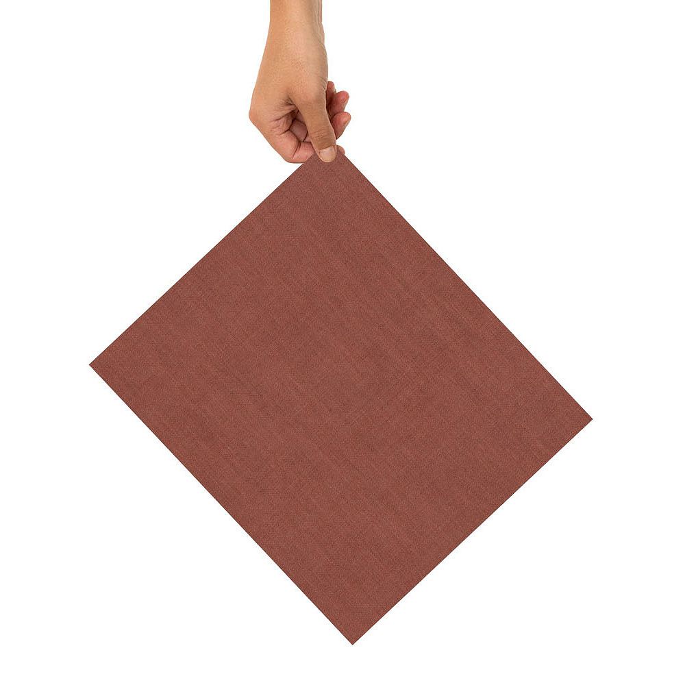 Hand hält ein rautenförmiges, braunes Blatt Papier vor weißem Hintergrund.