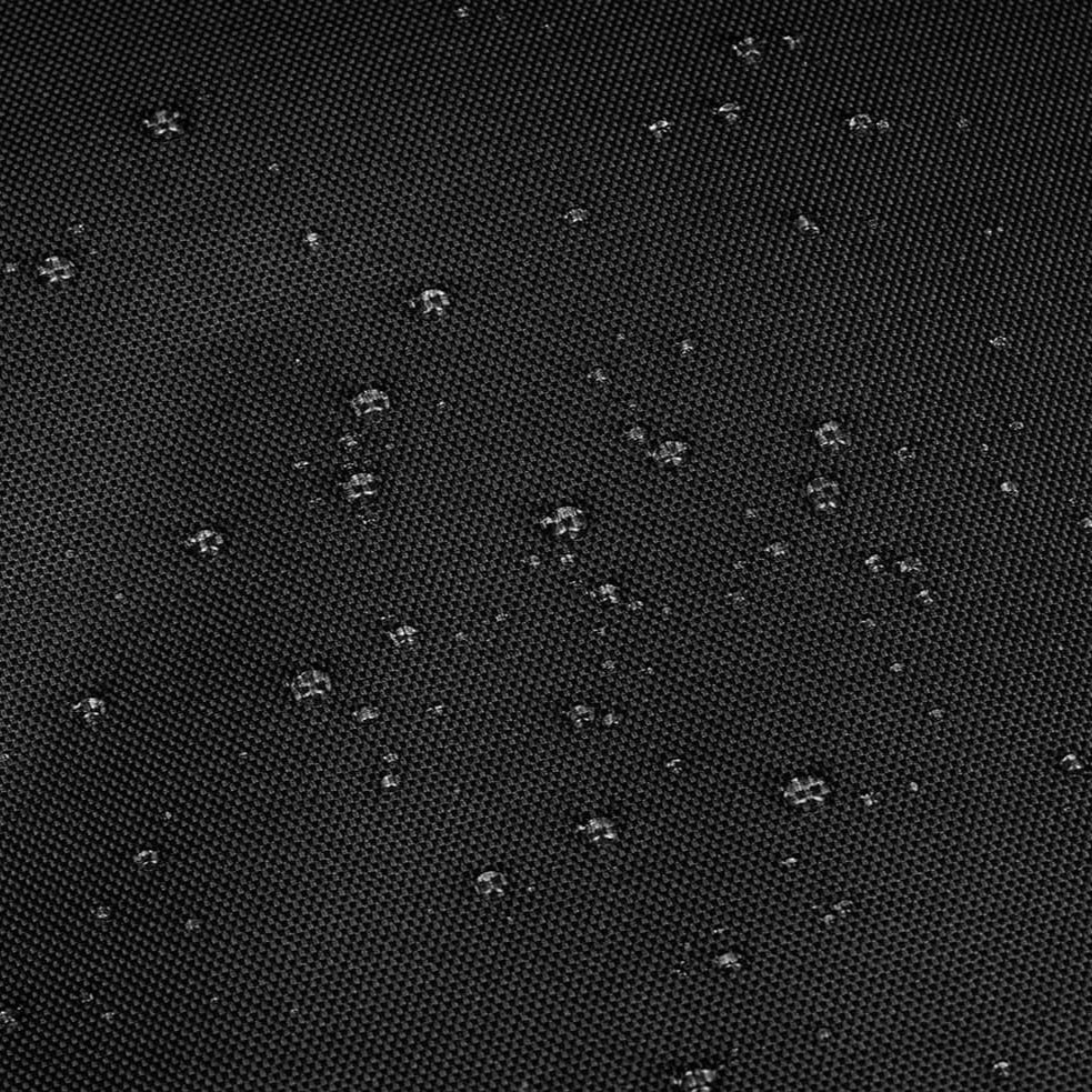 Wassertropfen auf schwarzem, texturiertem Stoff zeigen die wasserabweisende Eigenschaft des Materials.