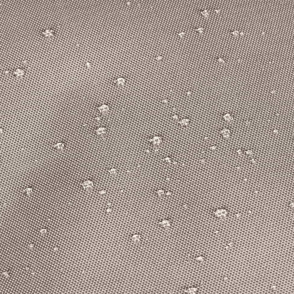 Wassertropfen auf einem wasserabweisenden, beige-grauen Textilgewebe.