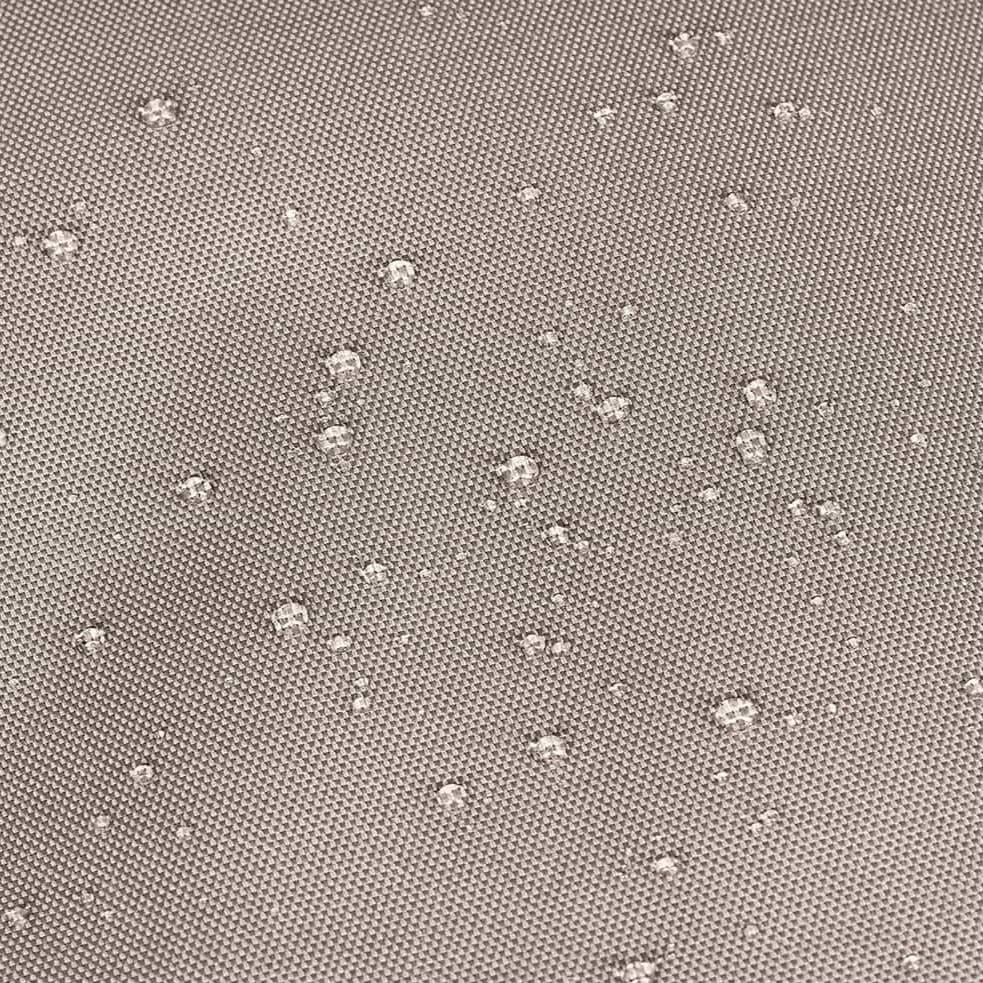 Wassertropfen auf einer grauen, strukturierten Oberfläche.