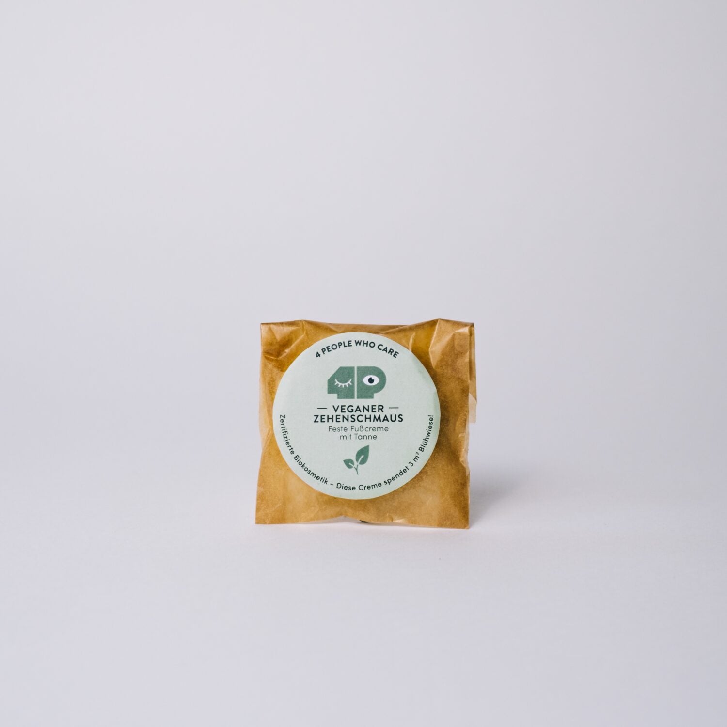 Verpackte vegane Fußcreme mit Tannenduft auf weißem Hintergrund, etikettiert mit "Zehenschmaus".