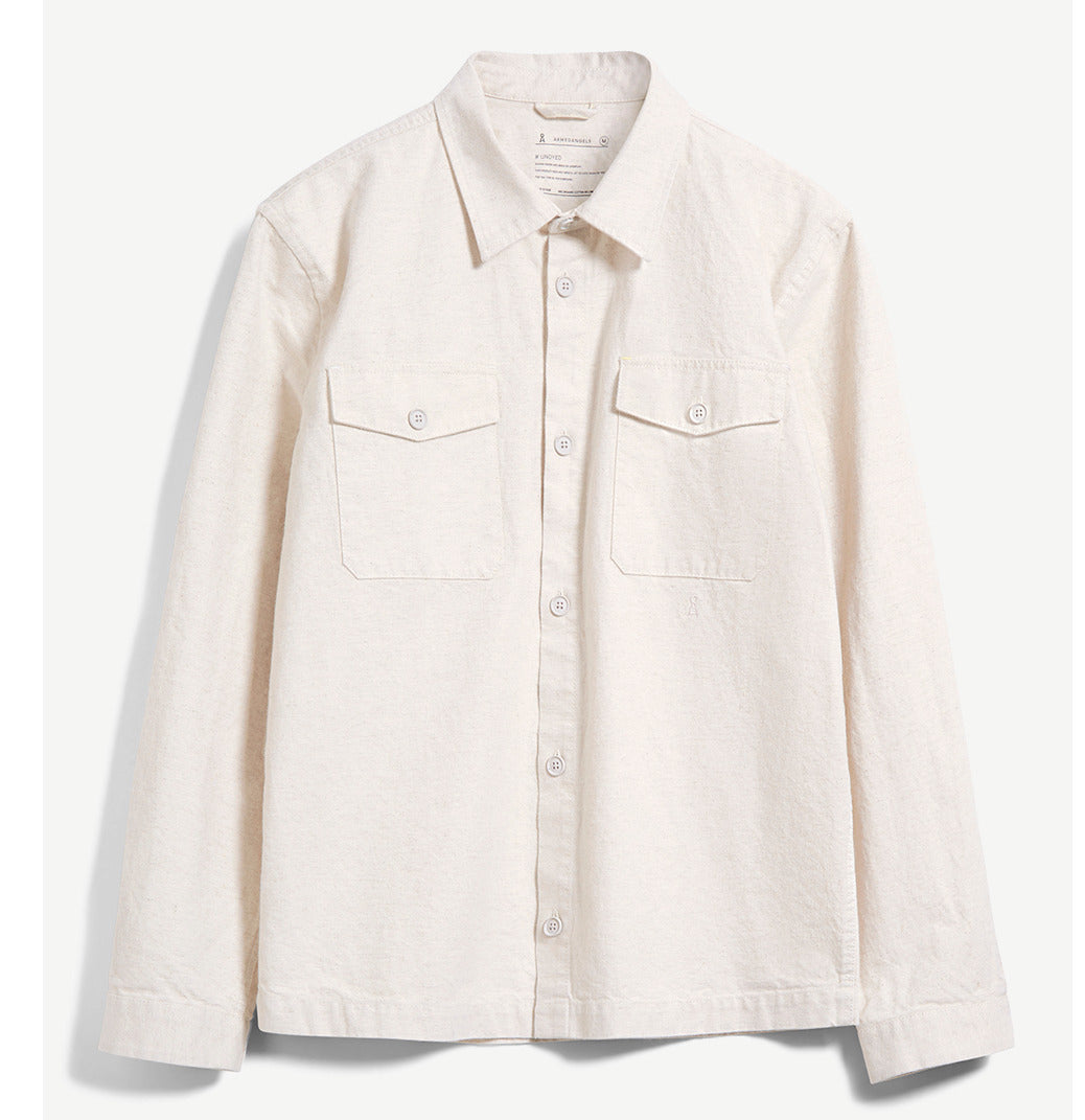 Beiges Hemd mit langen Ärmeln, Brusttaschen und Knopfleiste auf weißem Hintergrund.