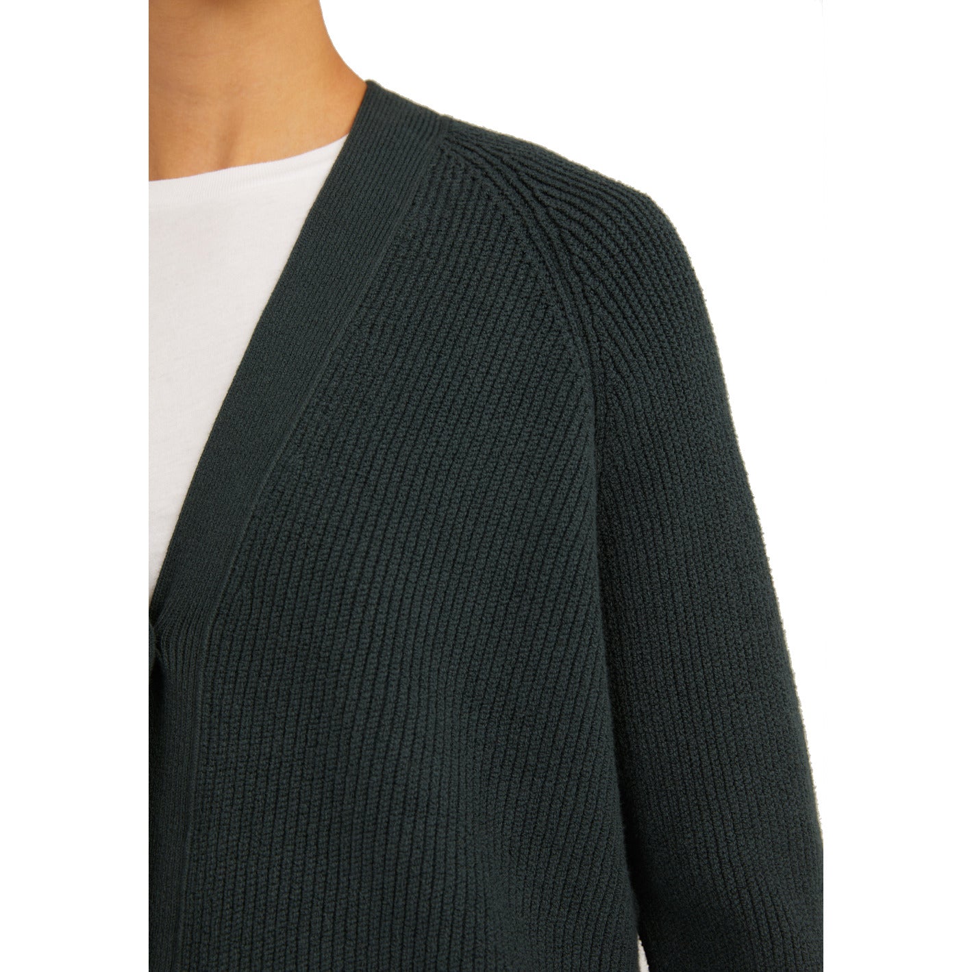 Nahaufnahme eines dunkelgrünen, gerippten Strickpullovers über einem weißen T-Shirt.