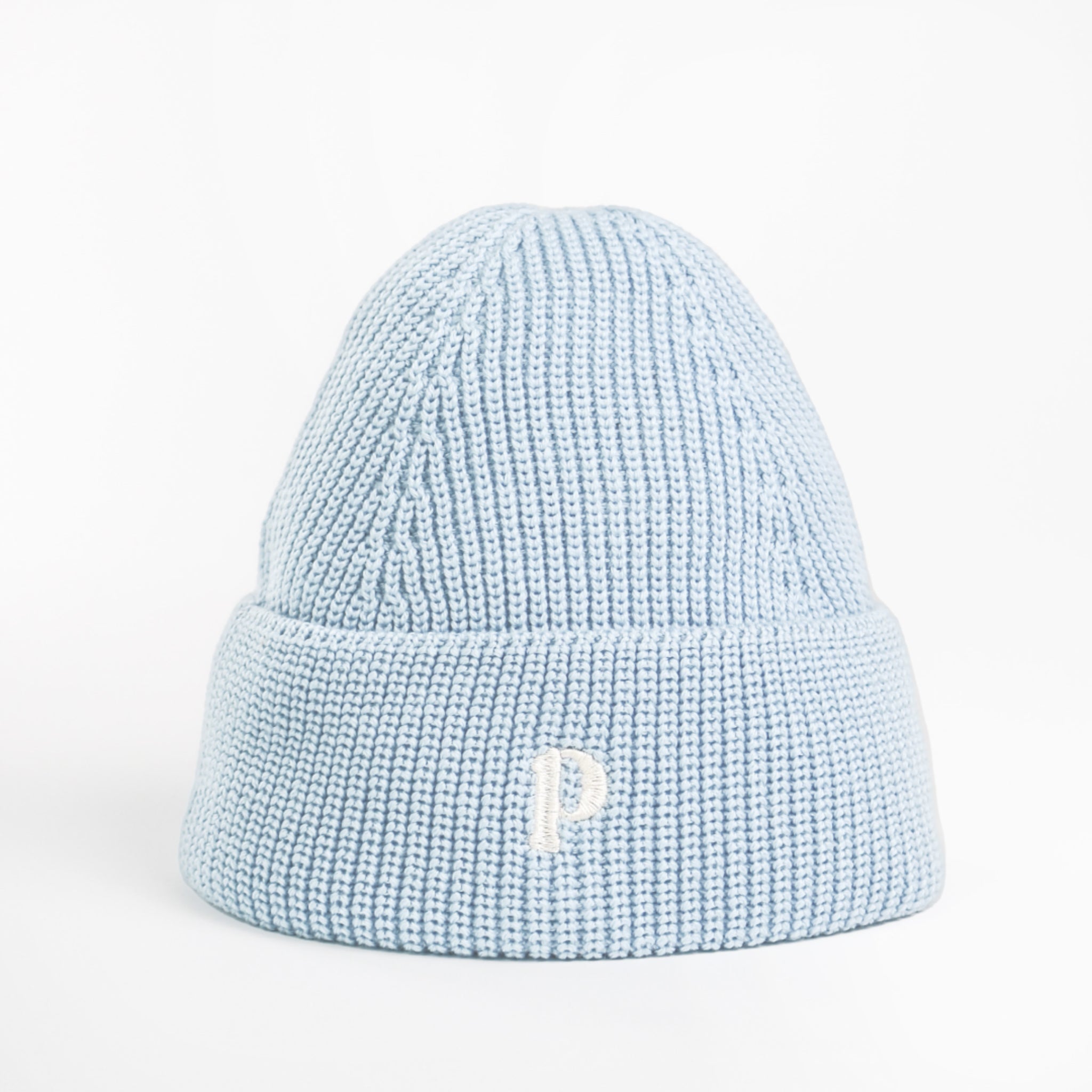 Hellblaue Strickmütze mit umgeschlagenem Rand und einem gestickten weißen Buchstaben "P" auf der Vorderseite.