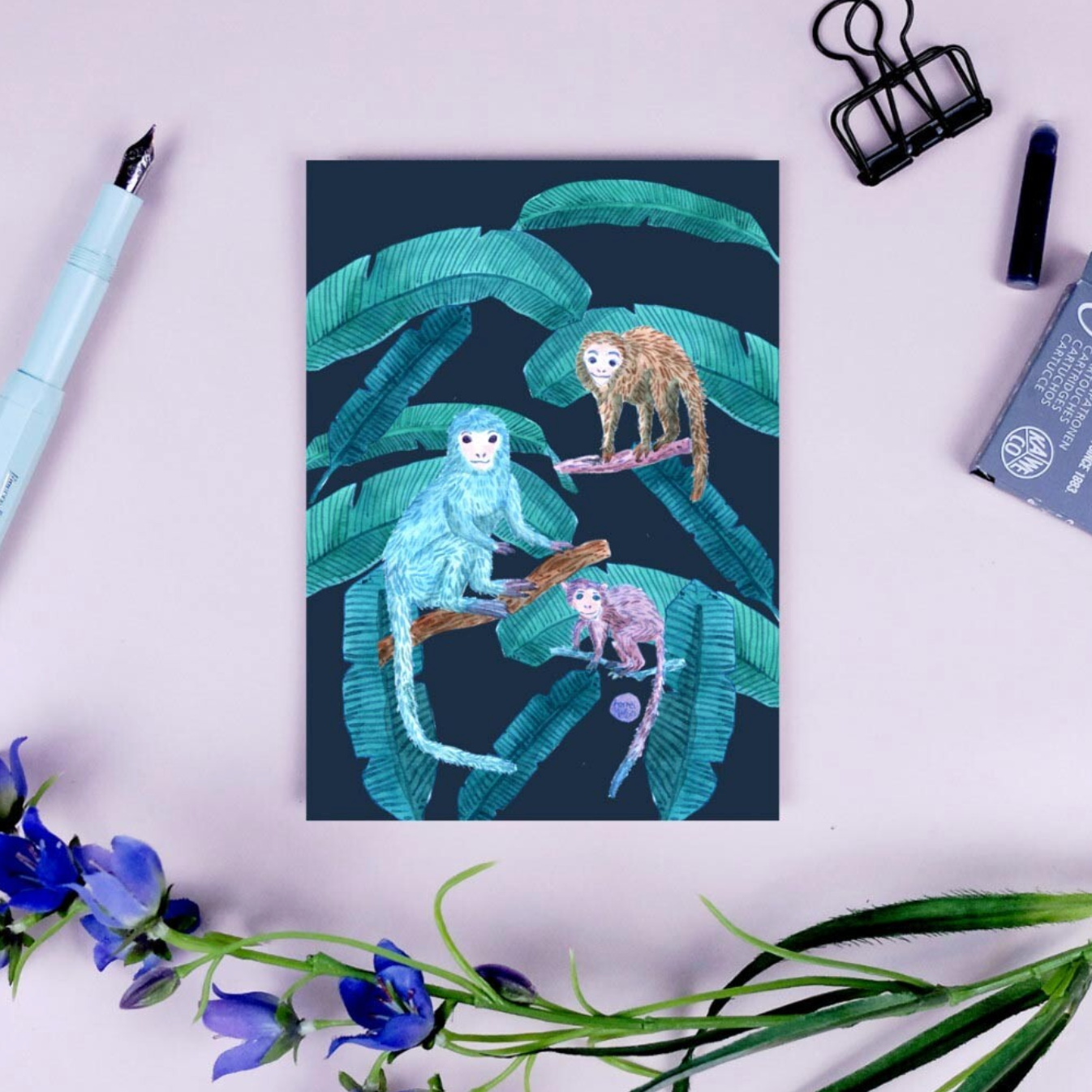 Illustration von drei Affen auf Ästen mit großen Blättern, umgeben von einem Stift, Blumen und Büroklammer.