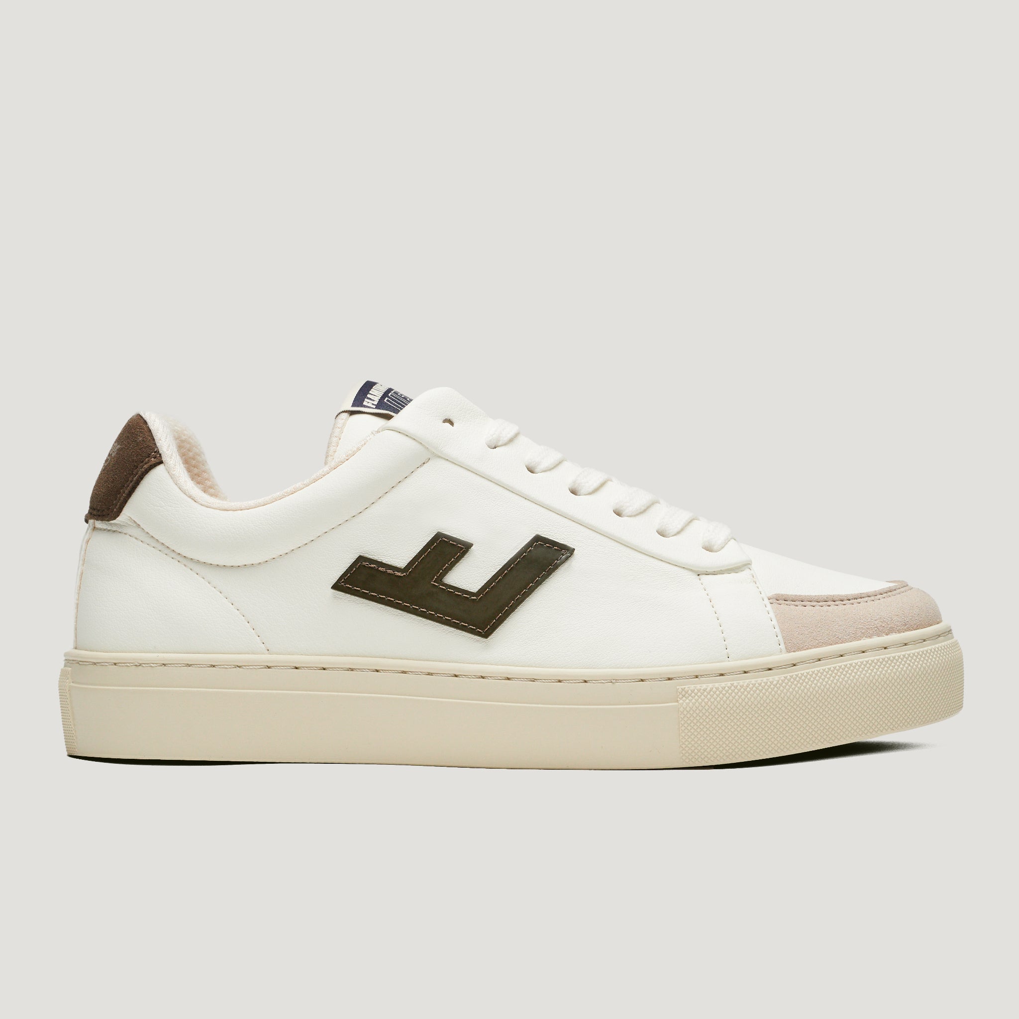 Weißer Sneaker mit cremefarbener Sohle, braunen Akzenten und einem dunklen seitlichen Logo auf einem grauen Hintergrund.