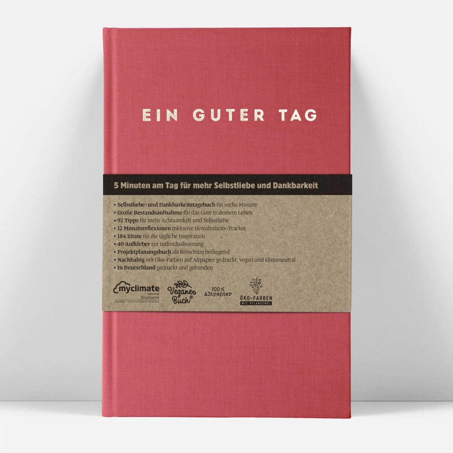 Rotes Buch mit Titel "Ein Guter Tag" und Beschreibung in deutscher Sprache auf einem braunen Einband.