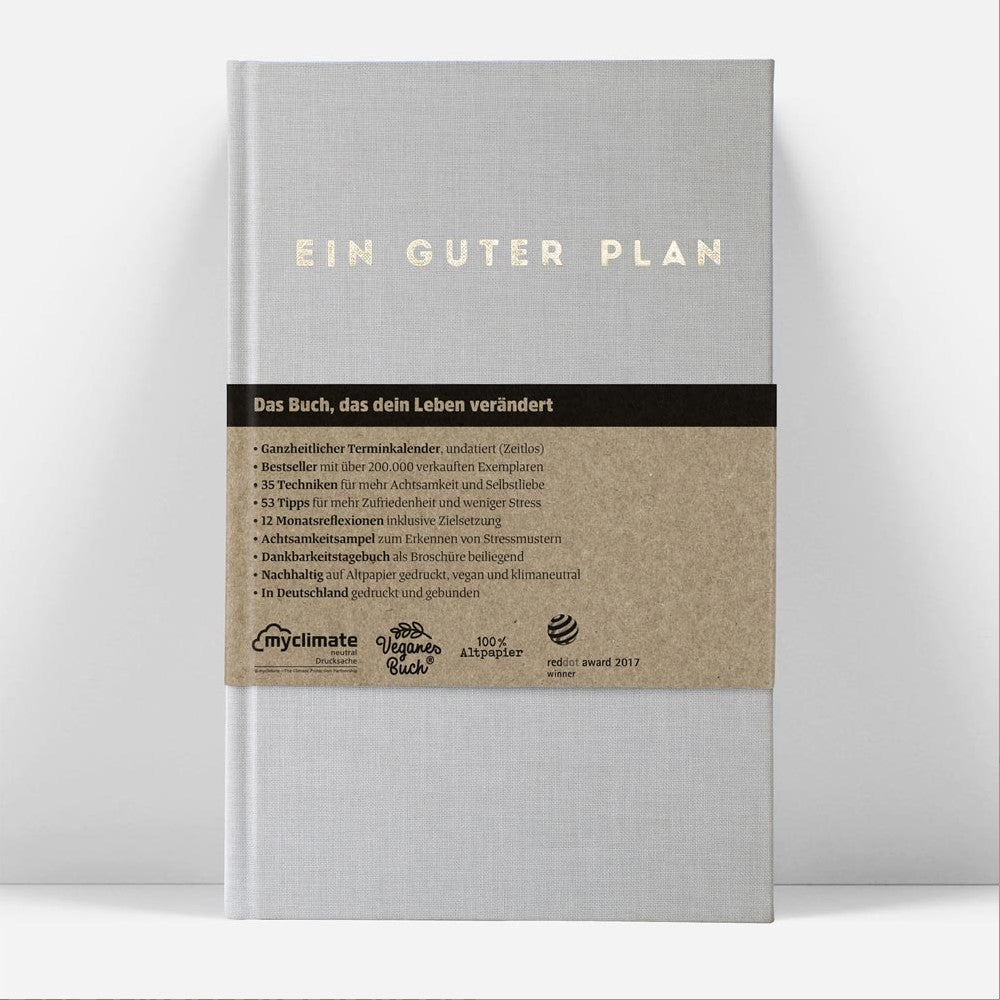 Ein graues Buch mit dem Titel "Ein Guter Plan" und einer Banderole mit Details über den Inhalt und die Nachhaltigkeit.