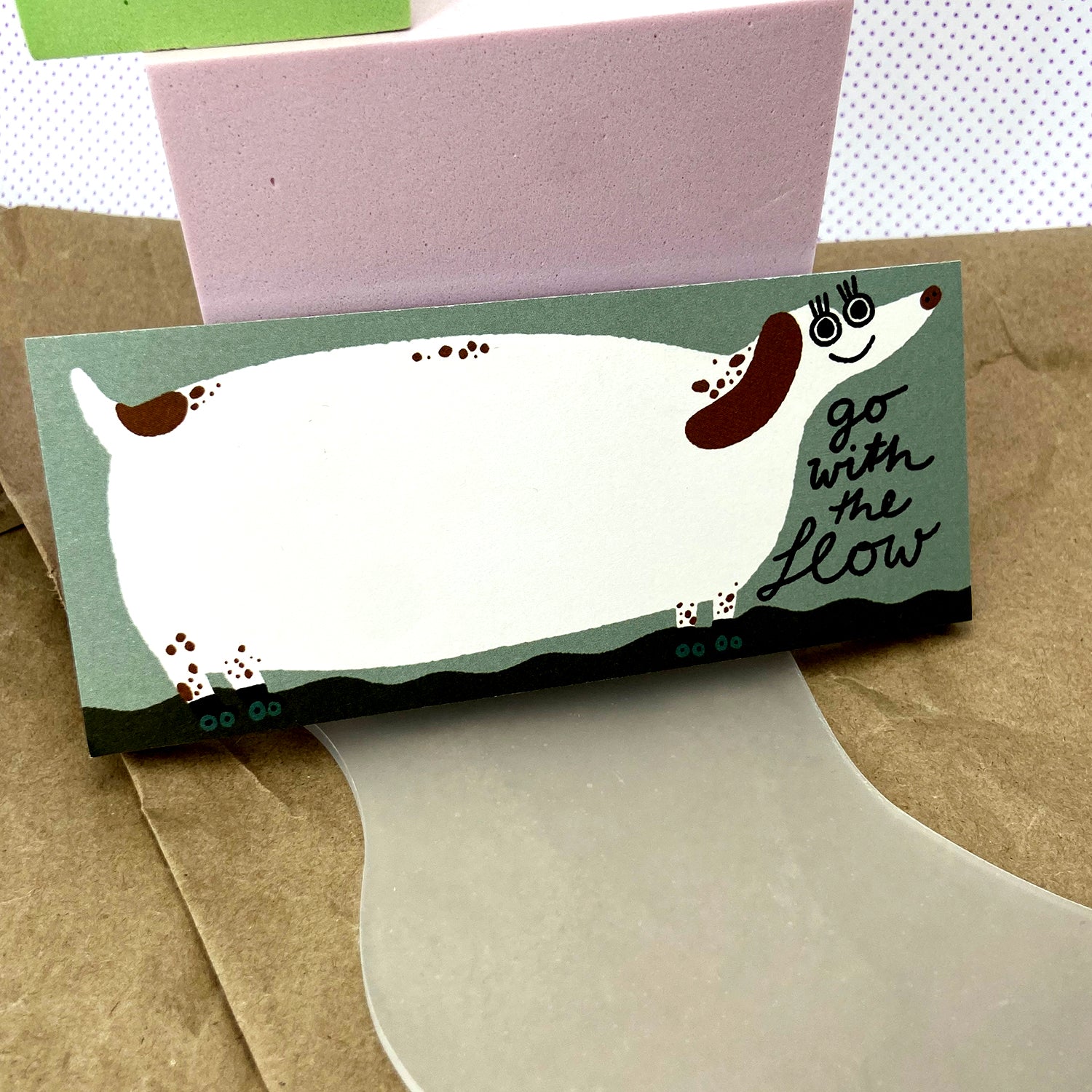 Illustration eines lächelnden Hundes mit der Aufschrift "go with the flow" auf einem farbigen Hintergrund.