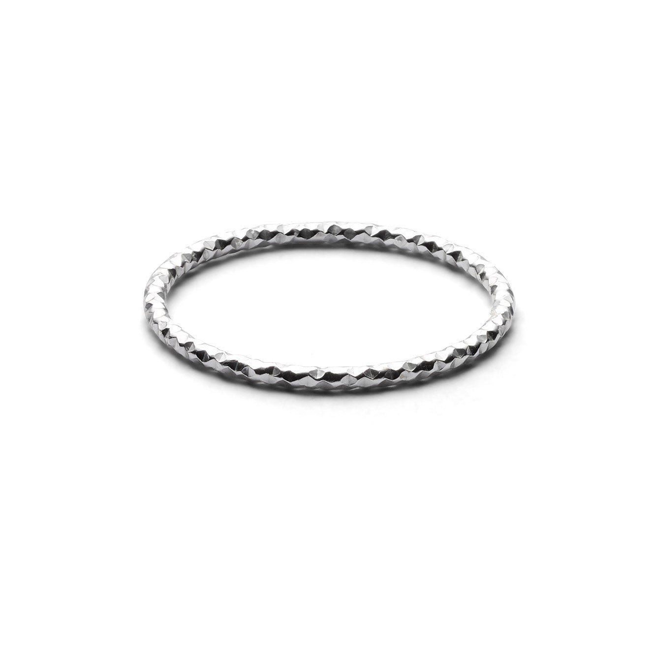 Ein dünner, silberner, gehämmerter Ring auf weißem Hintergrund.