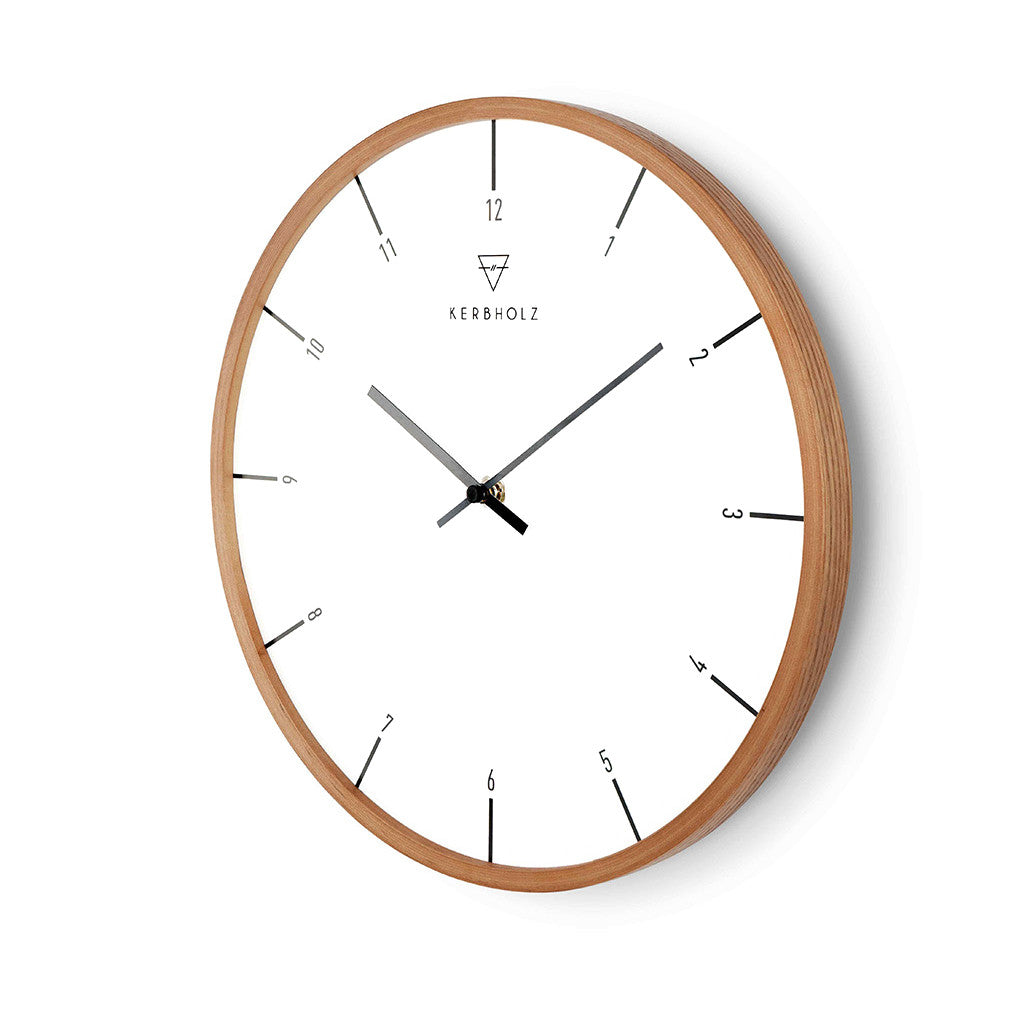Eine minimalistische Wanduhr mit Holzrahmen und dünnen schwarzen Zeigern auf weißem Zifferblatt.
