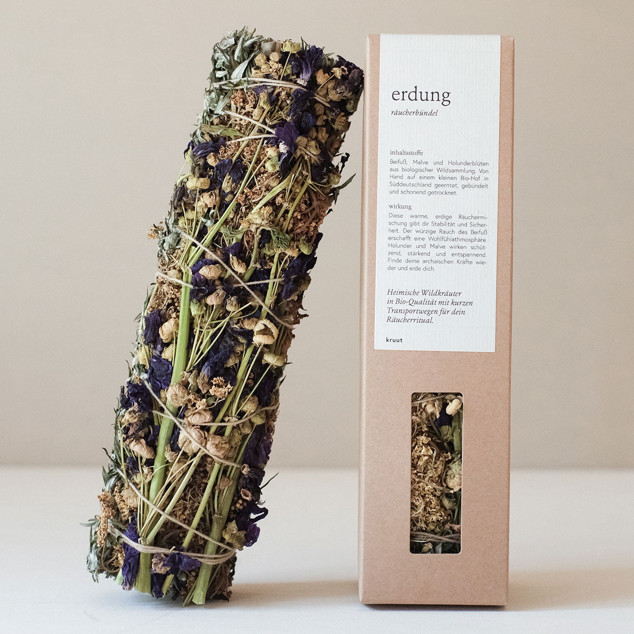 Bündel aus getrockneten Kräutern neben einer Verpackung mit der Aufschrift "erdung räucherbündel".