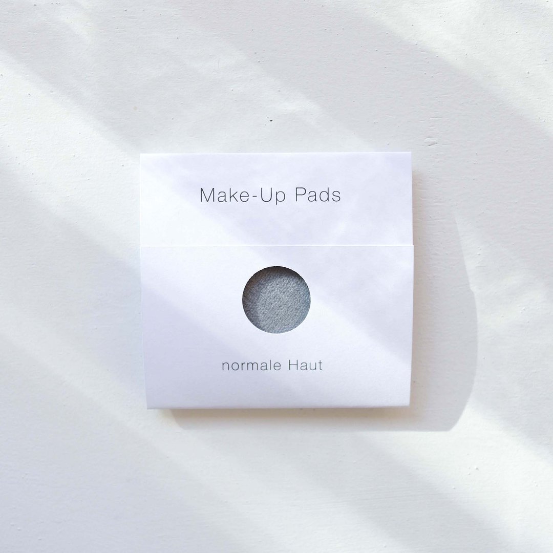 Verpackung mit der Aufschrift "Make-Up Pads" und "normale Haut", auf einem hellen Hintergrund liegend.