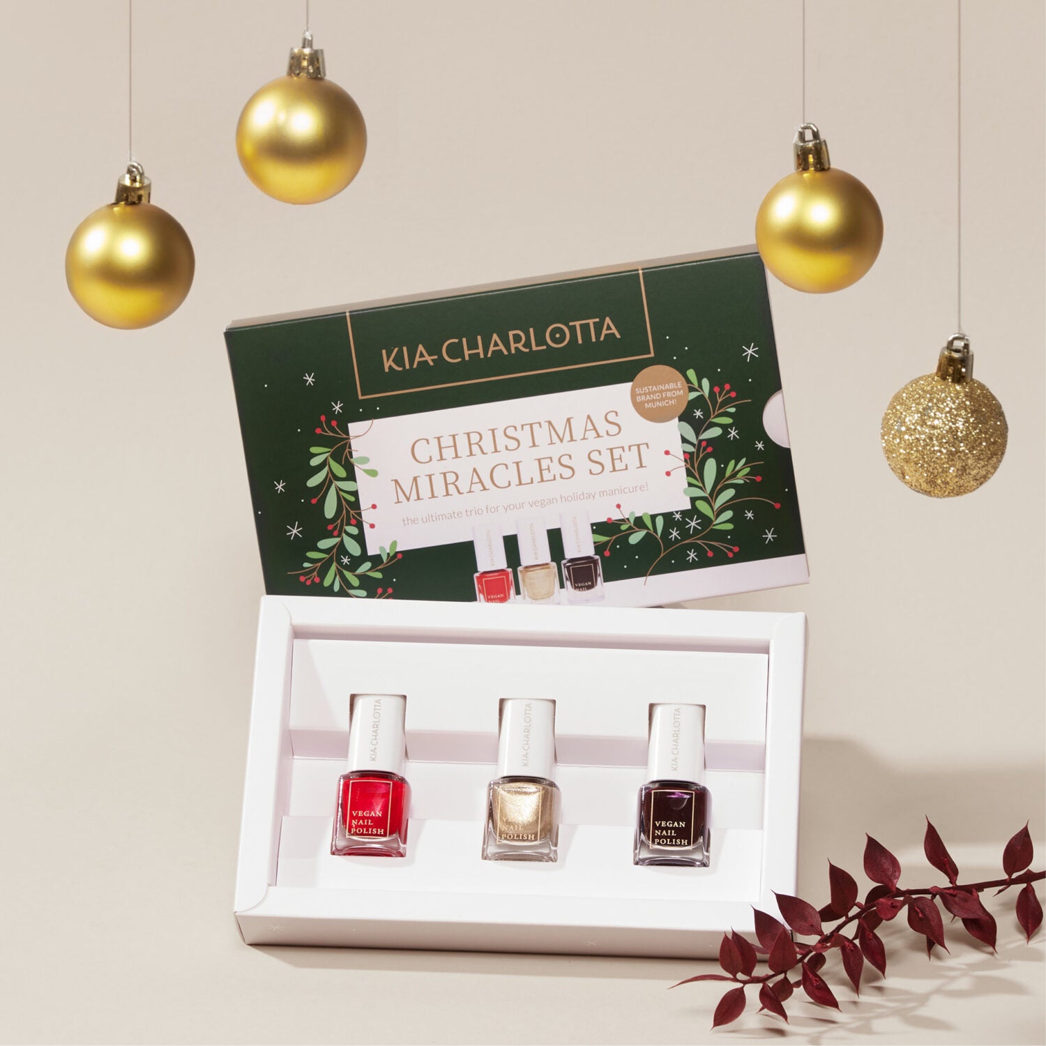 Nagellack-Set "Christmas Miracles" in einer offenen Schachtel mit drei Flaschen, umgeben von goldenen Weihnachtskugeln.