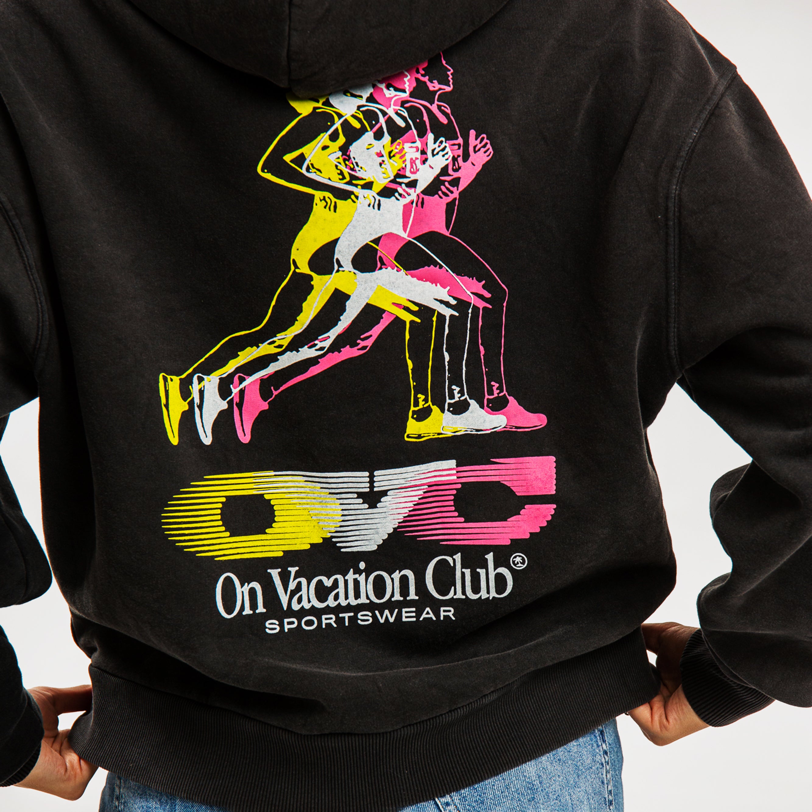 Rückseite eines schwarzen Hoodies mit mehrfarbigem Läufer-Design und der Aufschrift "On Vacation Club Sportswear".