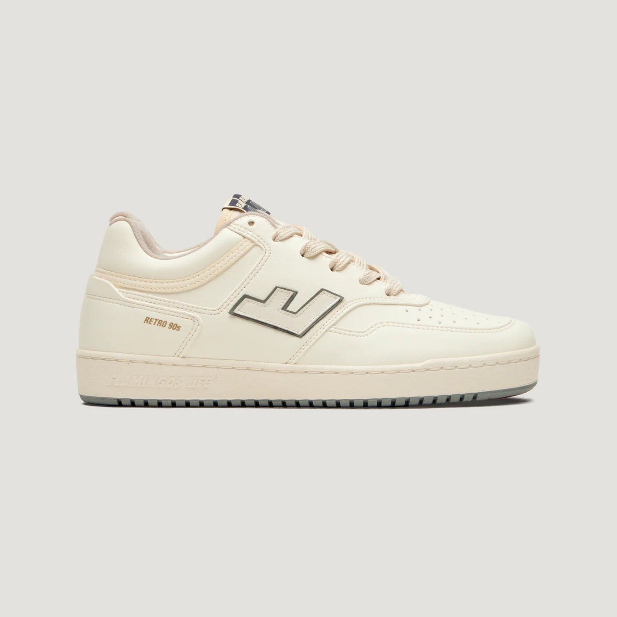 Cremfarbener Sneaker im Retro-Stil der 90er mit einem seitlichen Logo und klassischer Schnürung.