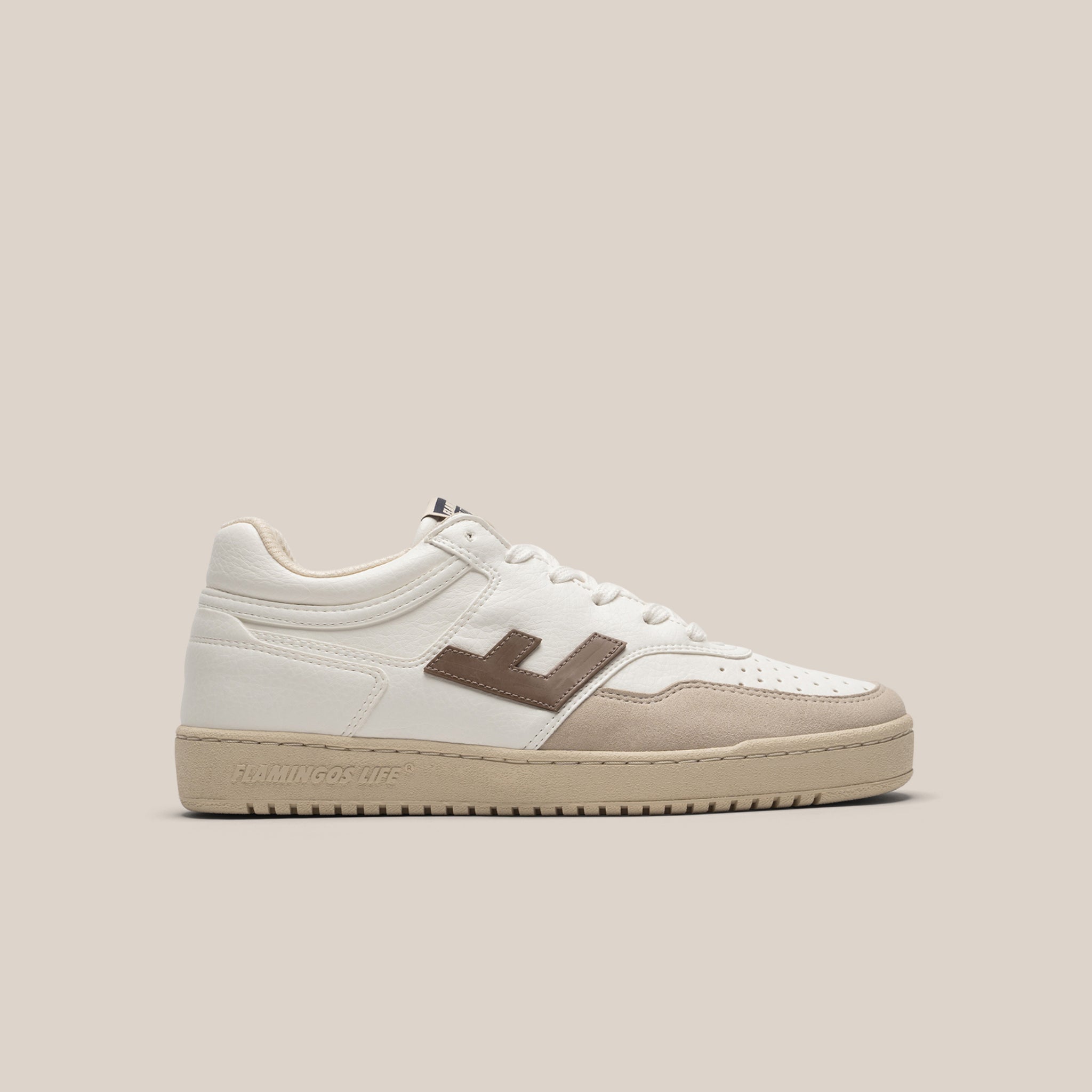 Weißer Sneaker mit beigem und braunem Detail, seitlicher Markenaufschrift und beigem Hintergrund.