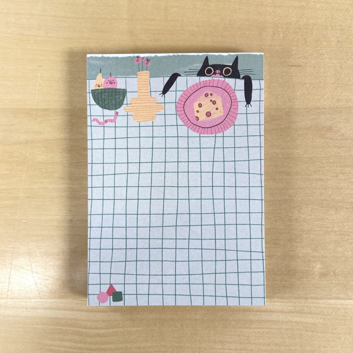 Illustration einer Katze und Speisen auf einem karierten Hintergrund auf einem Notizblock.