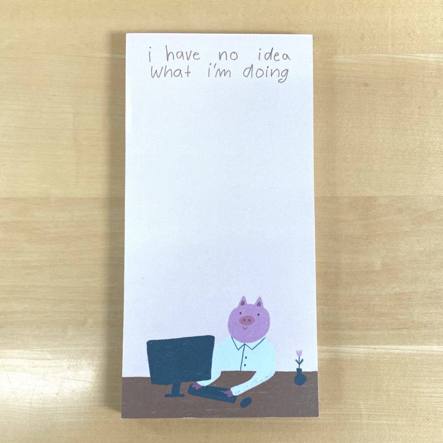 Ein Notizblock zeigt ein Schwein in einem Hemd an einem Computer, darüber steht: "I have no idea what I'm doing".