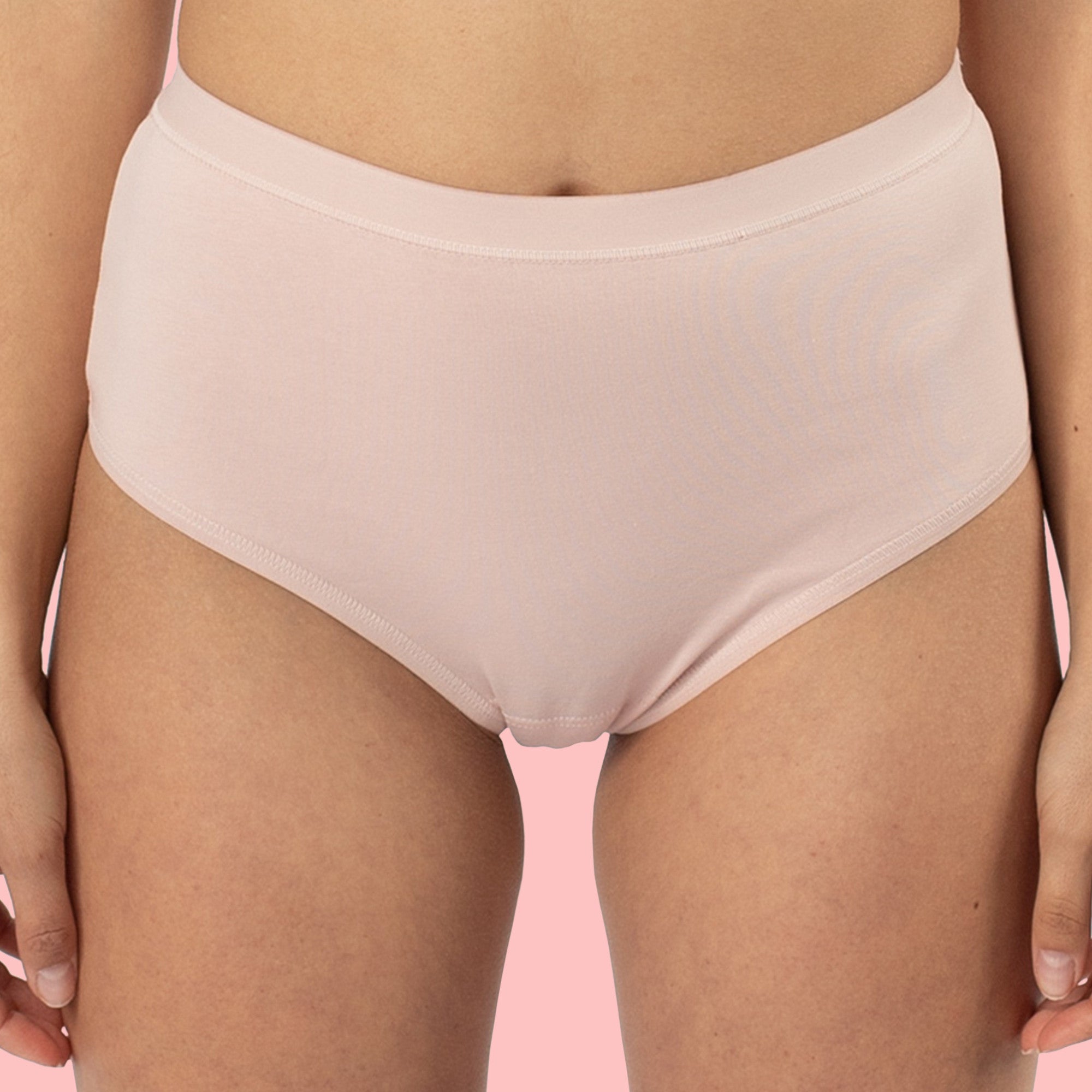 Person in hautfarbener Unterwäsche vor rosa Hintergrund.