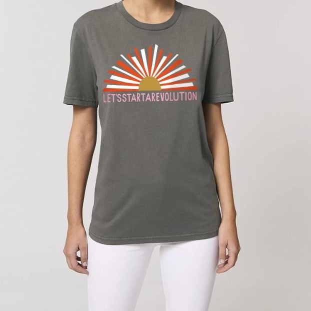 Person trägt ein graues T-Shirt mit stilisiertem Sonnenaufgang und dem Schriftzug "LET'S START A REVOLUTION".