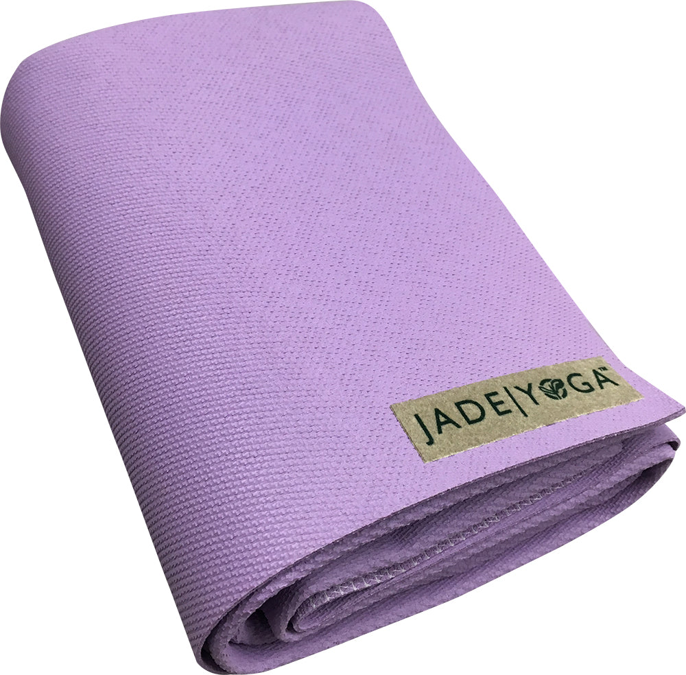 Zusammengefaltete lila Yogamatte mit dem Logo "JADE YOGA" auf dem Etikett.