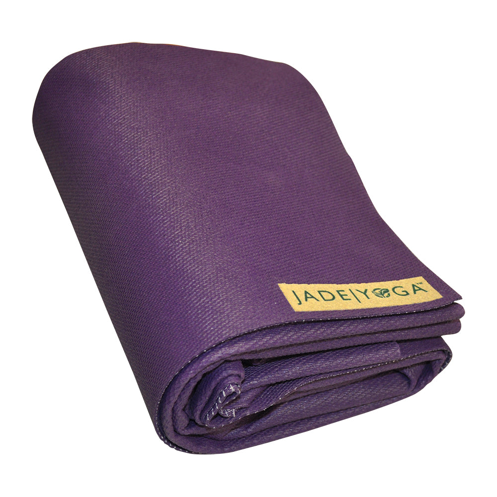 Lila zusammengerollte Yogamatte mit einem gelben Etikett mit der Aufschrift "Jade Yoga".