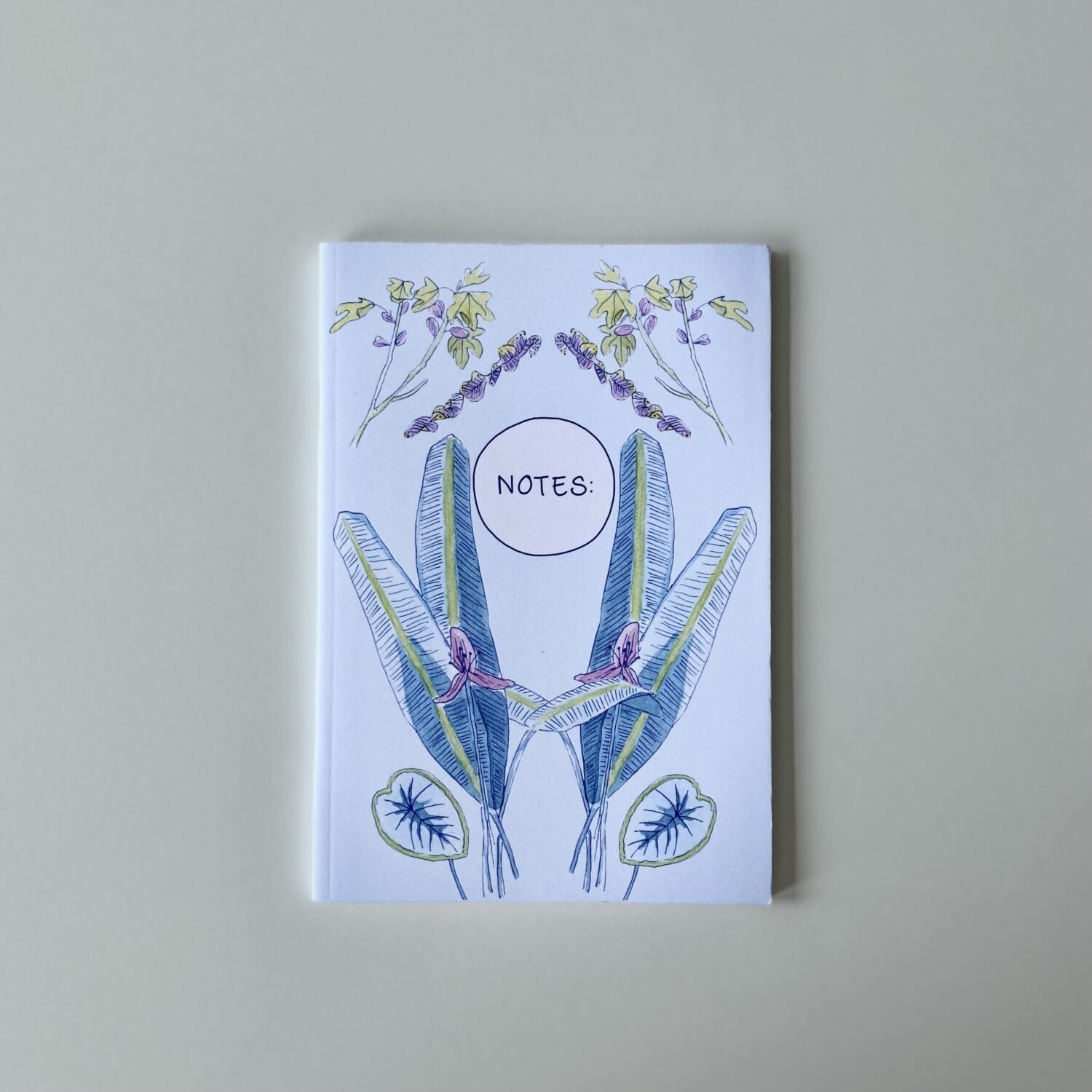 Notizbuch mit floralen Illustrationen und dem Wort "NOTES" auf dem Cover.