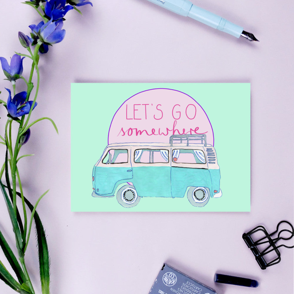 Illustration eines blauen Vans mit dem Text "LET'S GO somewhere" auf einer Karte, umgeben von Blumen und Schreibwaren.