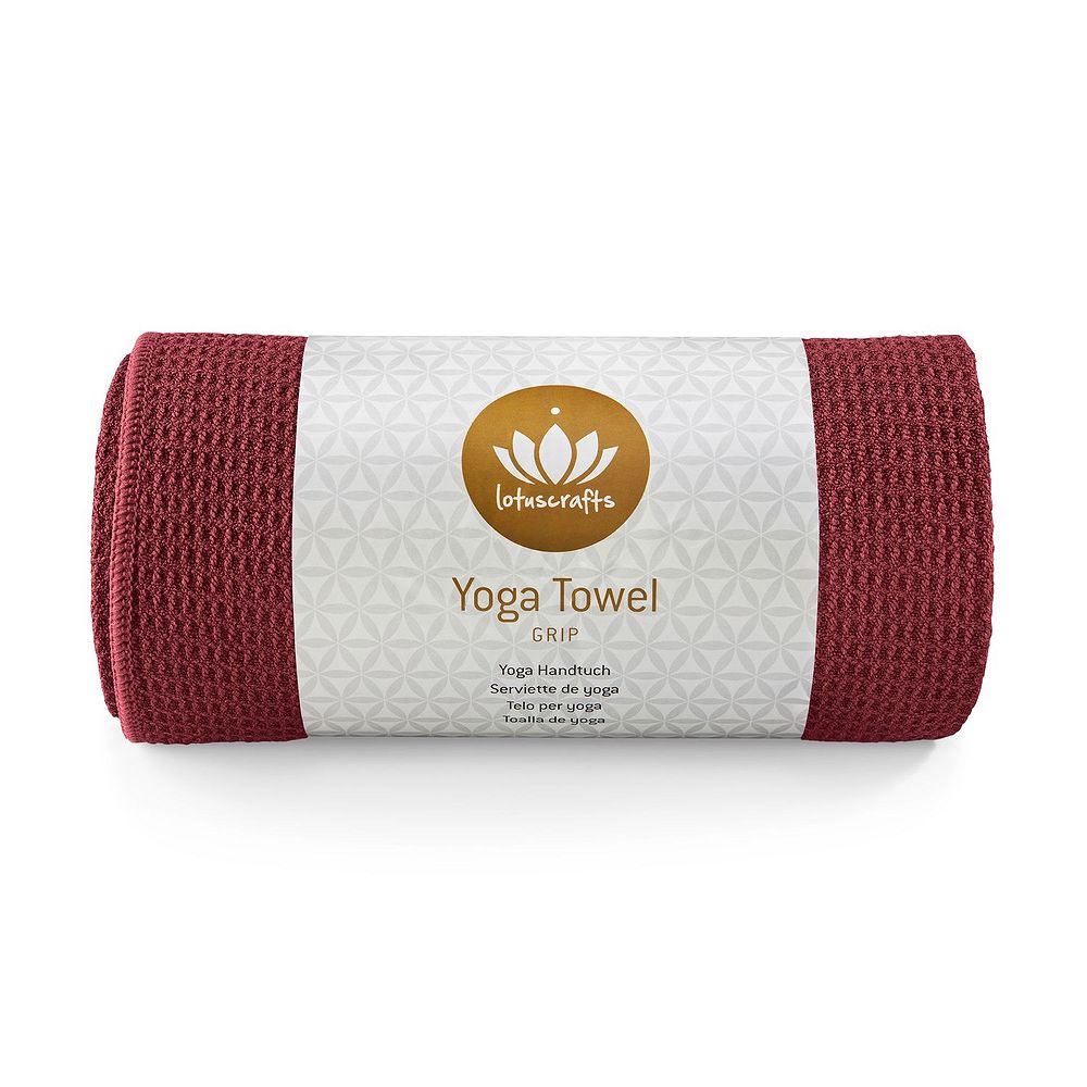 Gerolltes, rotes Yoga-Handtuch mit einem weißen Etikett, auf dem ein goldenes Lotus-Logo und "Yoga Towel" steht.