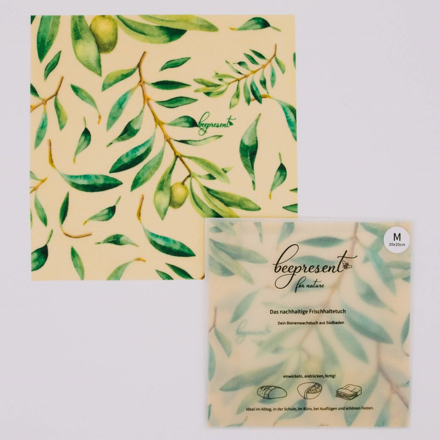 Grünes Blättermuster auf Bienenwachstuch mit "beepresent" Logo, nächste zu einer verpackten Version im gleichen Design.