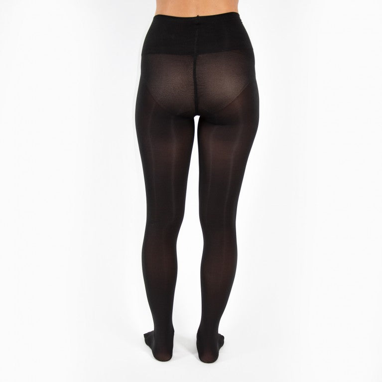 Rückansicht einer Person, die schwarze, durchsichtige Strumpfhosen trägt, vor einem weißen Hintergrund.