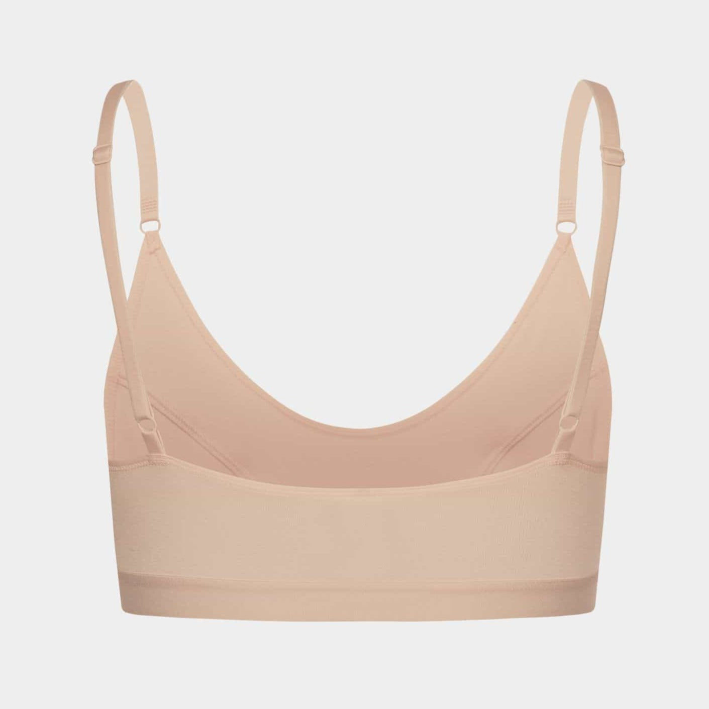 Beiger Bralette mit dünnen verstellbaren Trägern, auf weißem Hintergrund fotografiert.